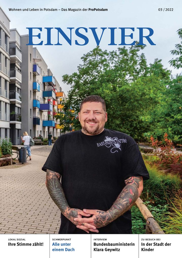 Cover der neuen EINSVIER mit einem lächelnden Mann mit tattowierten Unterarmen