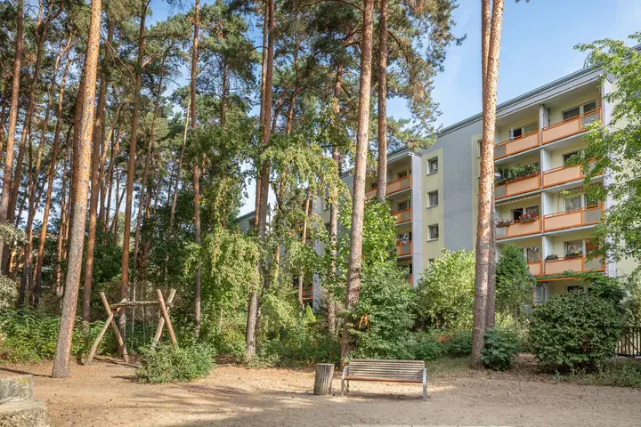 dichter Baumbestand und sanierter Plattenbau