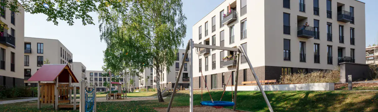 Das Bild zeigt neue Wohnhäuser und einen Spielplatz im Bornstedter Feld.
