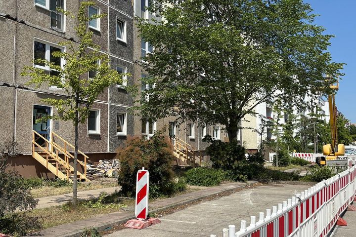 Abgesperrter Straßenbereich vor einem unsanierten Plattenbau in der Wolfgang-Staudte-Straße.
