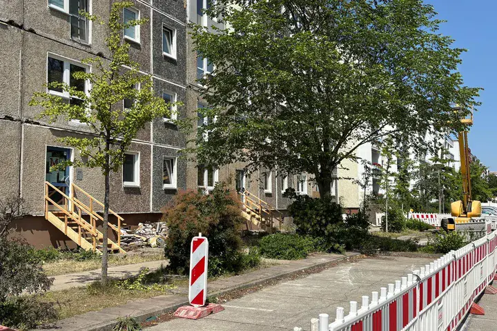 Abgesperrter Straßenbereich vor einem unsanierten Plattenbau in der Wolfgang-Staudte-Straße.