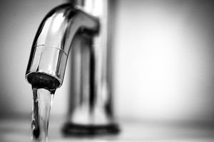 Das Bild zeigt einen laufenden Wasserhahn.