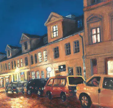 Dreietagige Häuserzeile in der Gutenbergstraße bei Nacht mit parkenden Autos im Vordergrund am Straßenrand