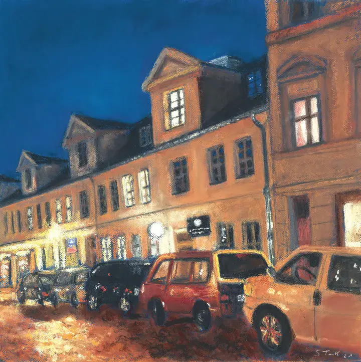 Dreietagige Häuserzeile in der Gutenbergstraße bei Nacht mit parkenden Autos im Vordergrund am Straßenrand