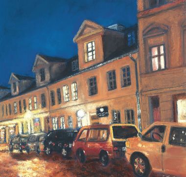 Dreietagige Häuserzeile in der Gutenbergstraße bei Nacht mit parkenden Autos im Vordergrund am Straßenrand