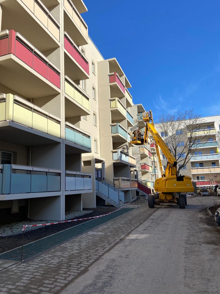 Sanierter Wohnblock im Willy-A.-Kleinau-Weg mit neuen Balkonen und farbigen Brüstungen, Bauarbeiten mit am Balkon.Kran
