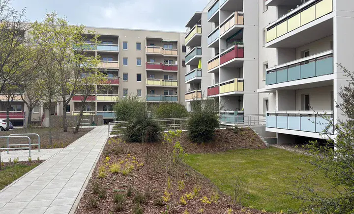 Sanierte Wohnanlage mit begrüntem Innenhof Modernisierte Mehrfamilienhäuser mit farbigen Balkonen, begrüntem Innenhof und barrierefreien Wegen