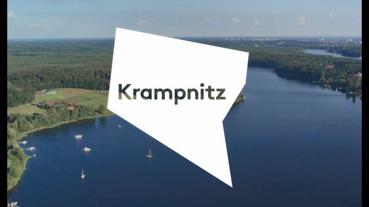 Luftaufnahme über die noch stehenden Häuserreihen des Krampnitz-Areals, welche fast verdeckt werden von vielen, dicht beieinander stehenden, grünen Laubbäumen.