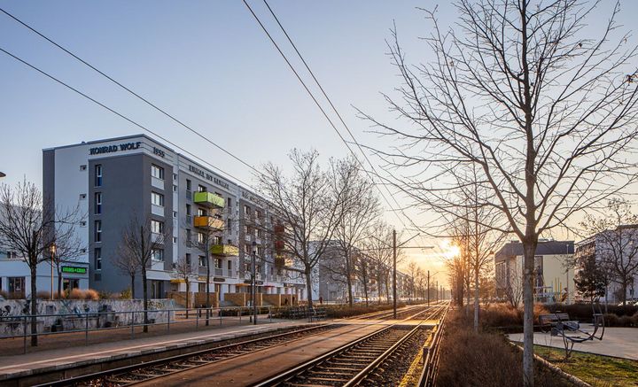 Die sanierte Rolle in der Konrad-Wolf-Allee in Drewitz mit Blick über den begrünten Mittelstreifen und Straßenbahnschienen im Abendlicht
