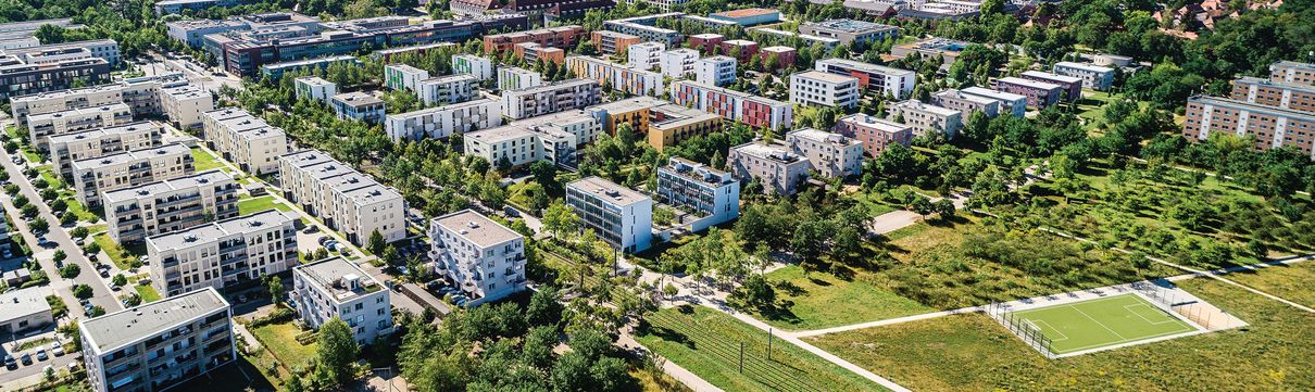 Das Wohnquartier Bornstedter Feld von oben. Es sind viele Gebäude und der Volkspark Potsdam zu sehen.