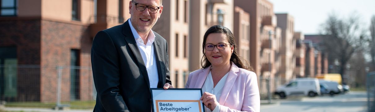 ProPotsdam-Geschäftsführer Bert Nicke und Bianca Künkel halten die Auszeichnungsurkunde für "A Great Place To Work