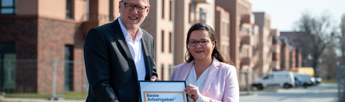 ProPotsdam-Geschäftsführer Bert Nicke und Bianca Künkel halten die Auszeichnungsurkunde für "A Great Place To Work