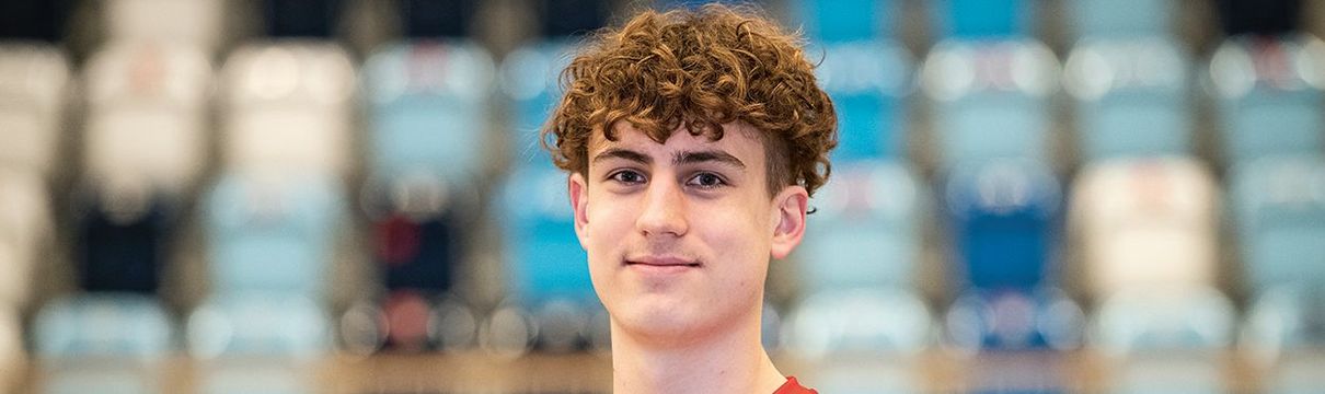 Ein 18-jähriger Junge im Trikot des Handballvereins 1. VfL Potsdam in einer Sporthalle, der MBS-Arena