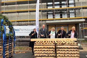 Geschäftsführer der ProPotsdam, der Oberbürgermeister und weitere Akteure hämmern Nägel in einen Holzbalken ein.